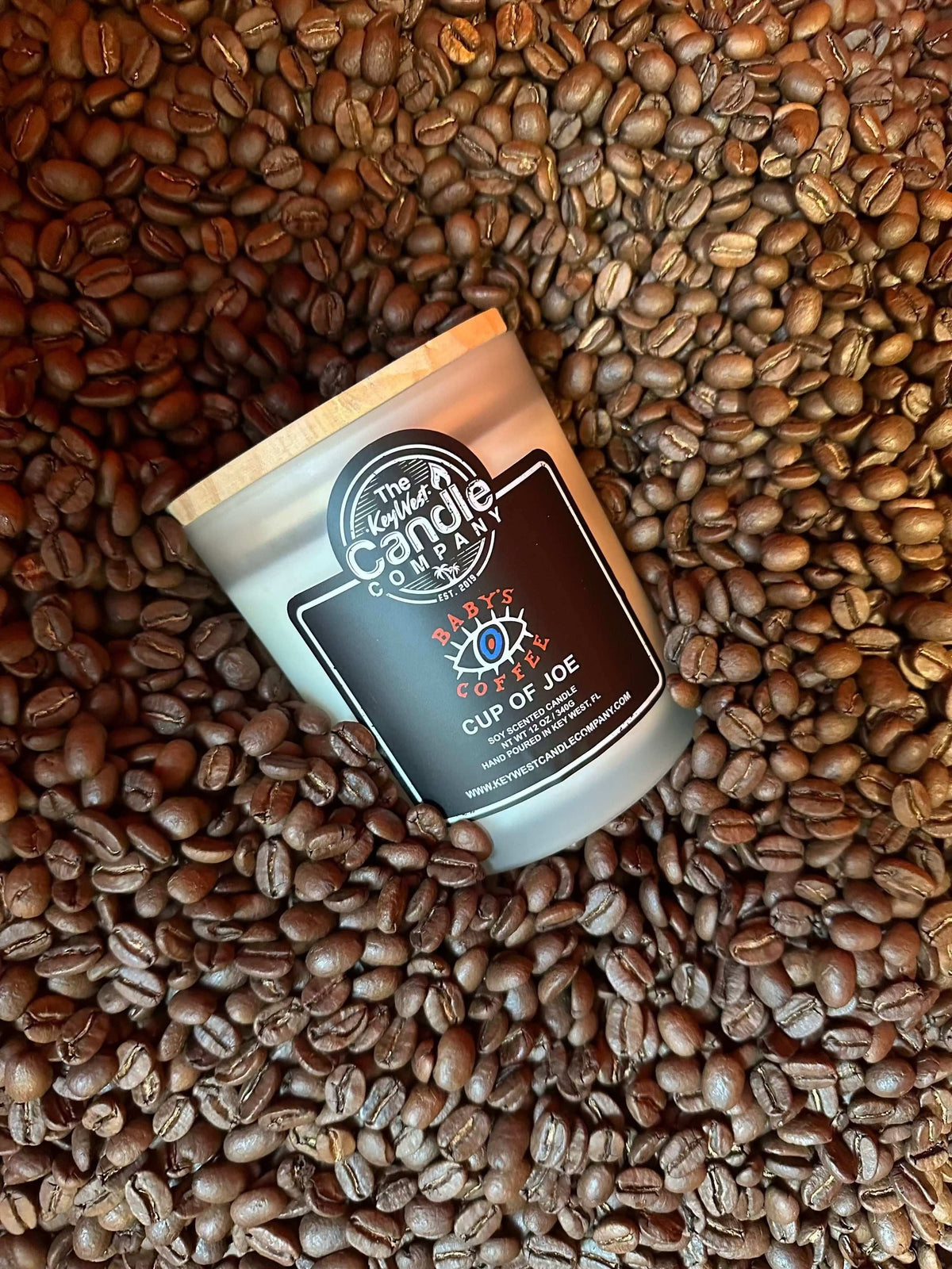 A Baby’s Coffee scented candle on roasted coffee beans