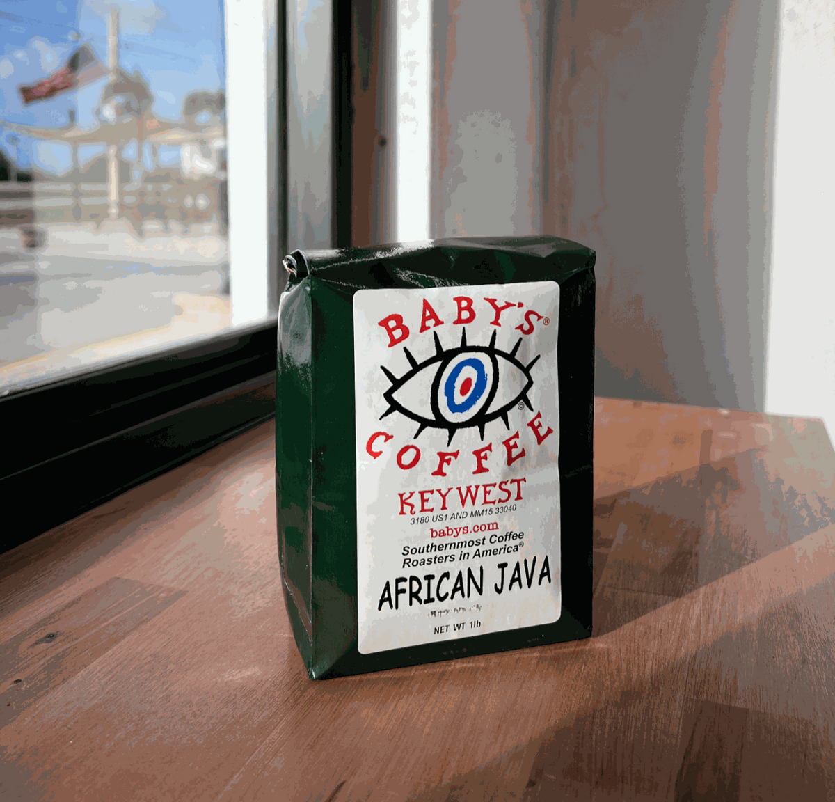 A bag of Baby’s African Java coffee beside the café window